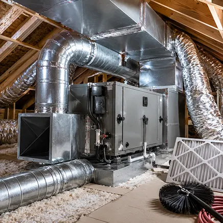 Residential HVAC air handler and connected ductwork installed in a clean attic utility space.